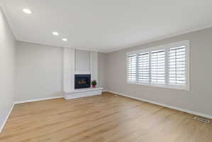 Living area featuring wood-look flooring and a white brick fireplace with a dark firebox