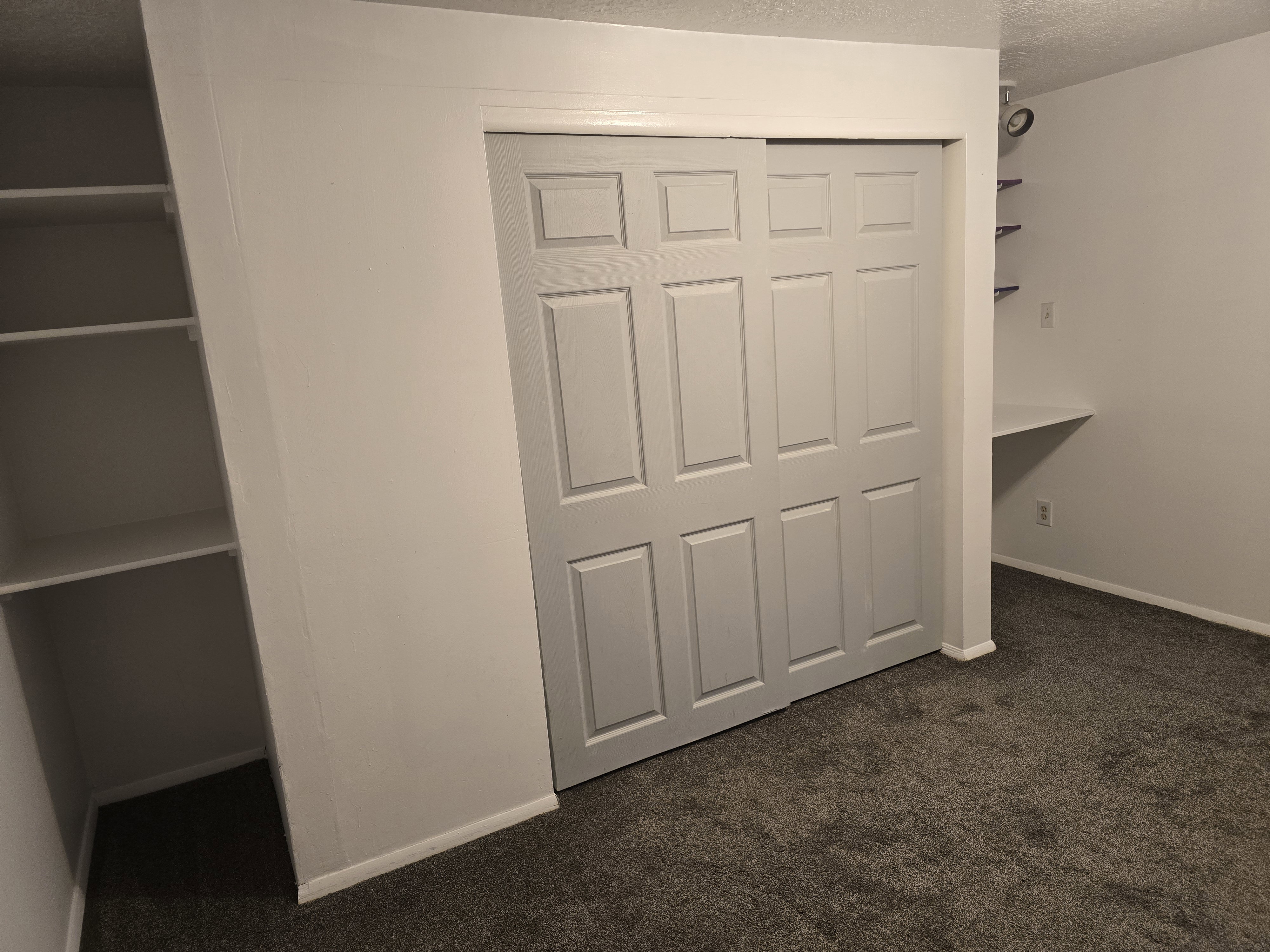 Gray sliding bifold closet doors with a paneled design