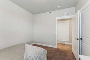 Carpeted room with light grey walls and white trim