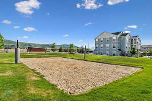 Sand volleyball court set within a manicured lawn, featuring net and posts