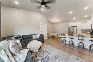 Vaulted ceiling living area with recessed lighting and a ceiling fan