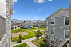 Landscaped grounds featuring walking paths, mature trees, and a sand court