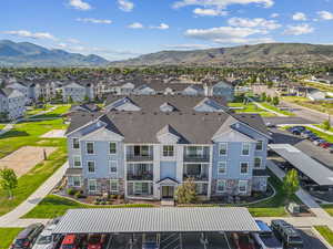 Multi-story residential building with light blue siding, white trim, and stone accents