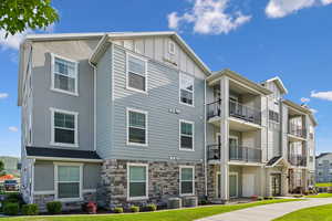 Contemporary multi-story building featuring stucco, horizontal siding, and stone veneer exterior finishes
