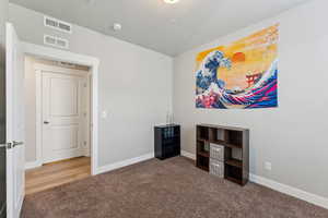 Carpeted room featuring light gray walls and white trim
