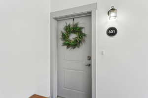 White painted door with decorative paneling and brushed nickel hardware