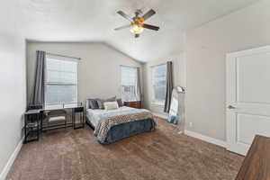 Vaulted ceiling bedroom featuring carpeting, an overhead ceiling fan with lighting, and two windows with blinds