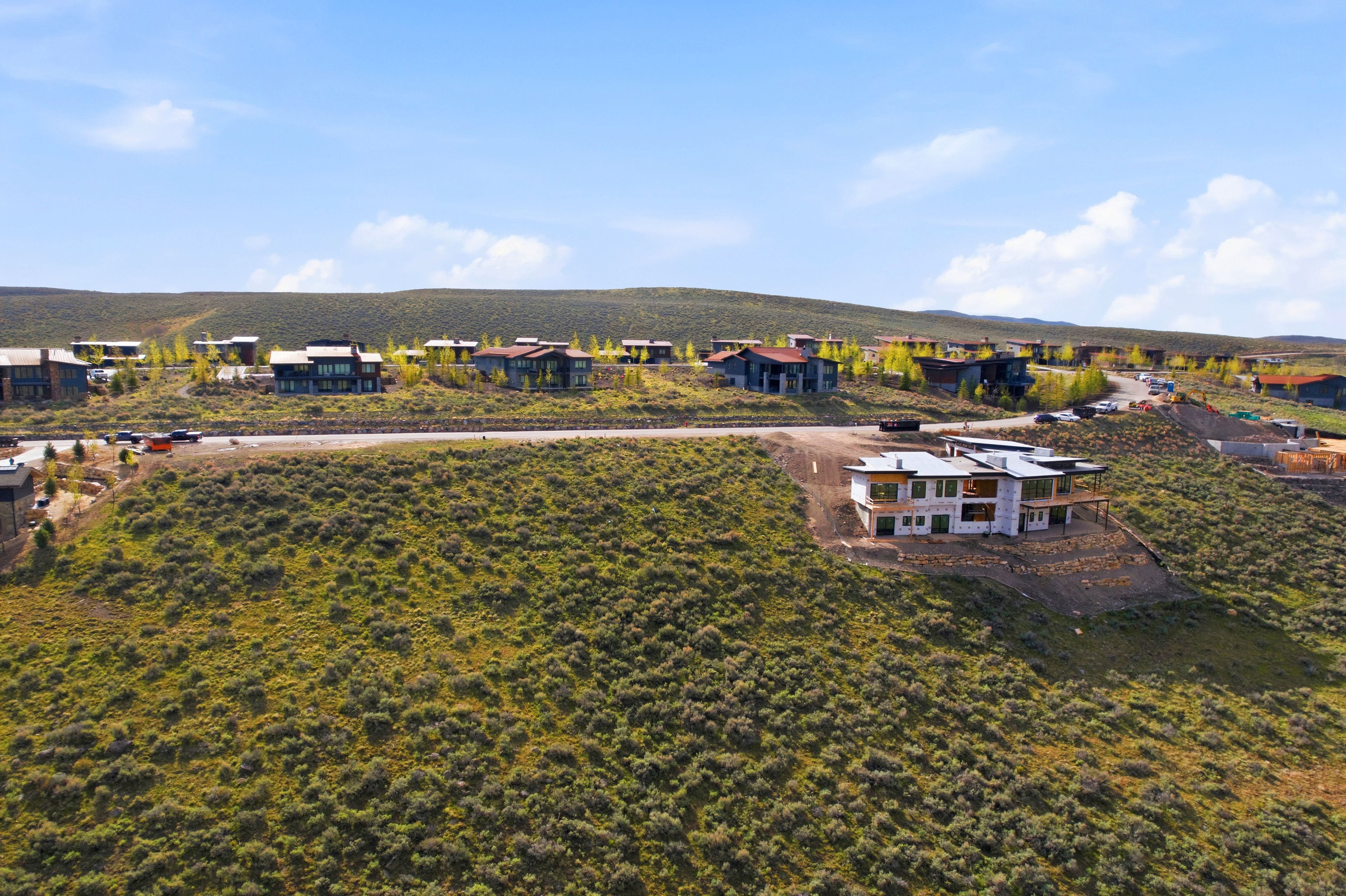 Developing hillside residential area featuring a partially constructed contemporary residence