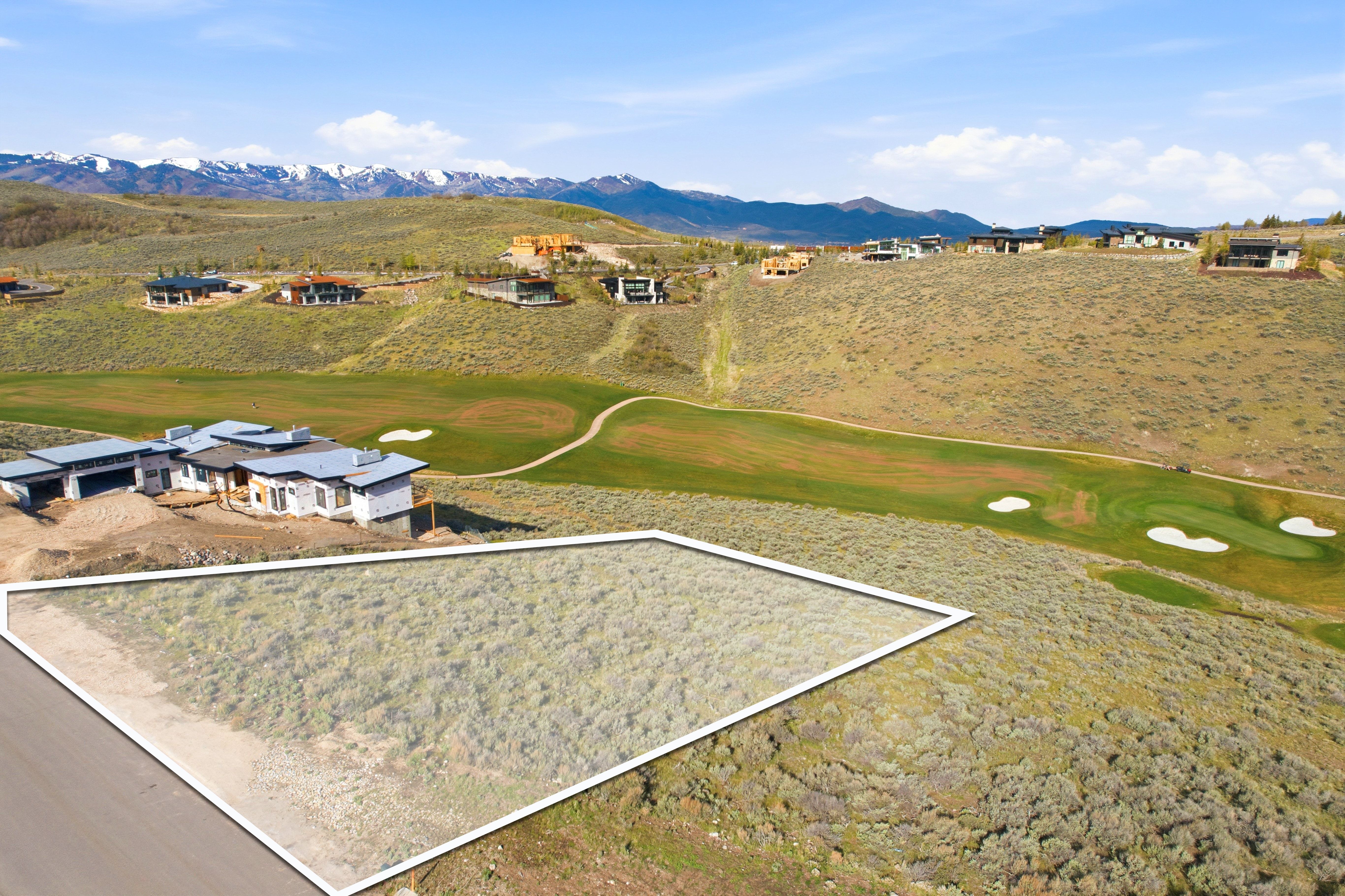 Expansive land parcel featuring natural shrubbery and a clear, level building area