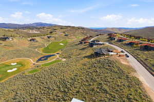Expansive golf course community featuring multiple fairways, greens, and water features set within a mountainous landscape
