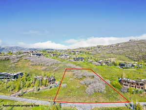 Elevated lot featuring a verdant hillside, surrounding residential properties, and distant mountain ranges