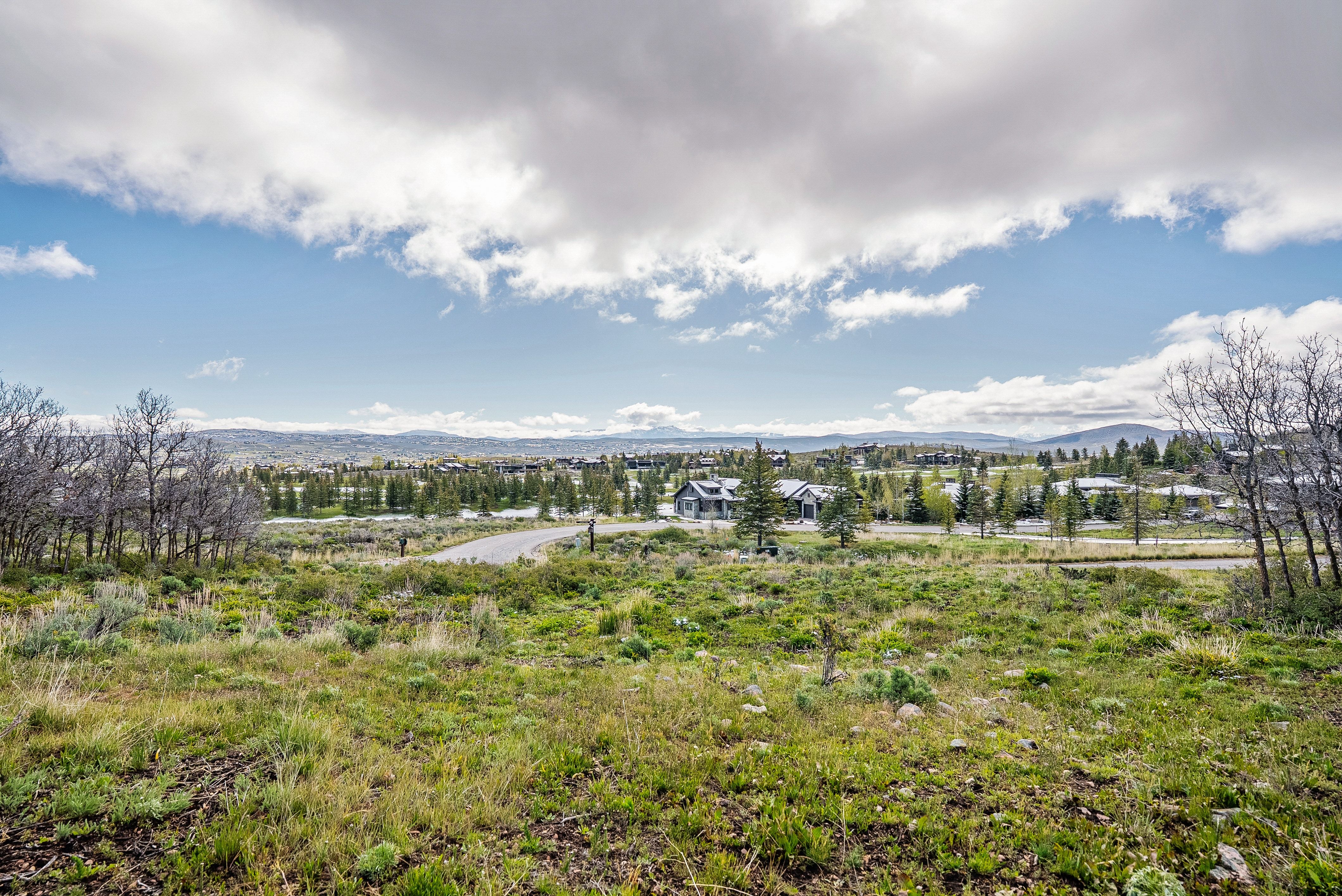 Expansive natural landscape featuring rolling terrain and distant mountain ranges