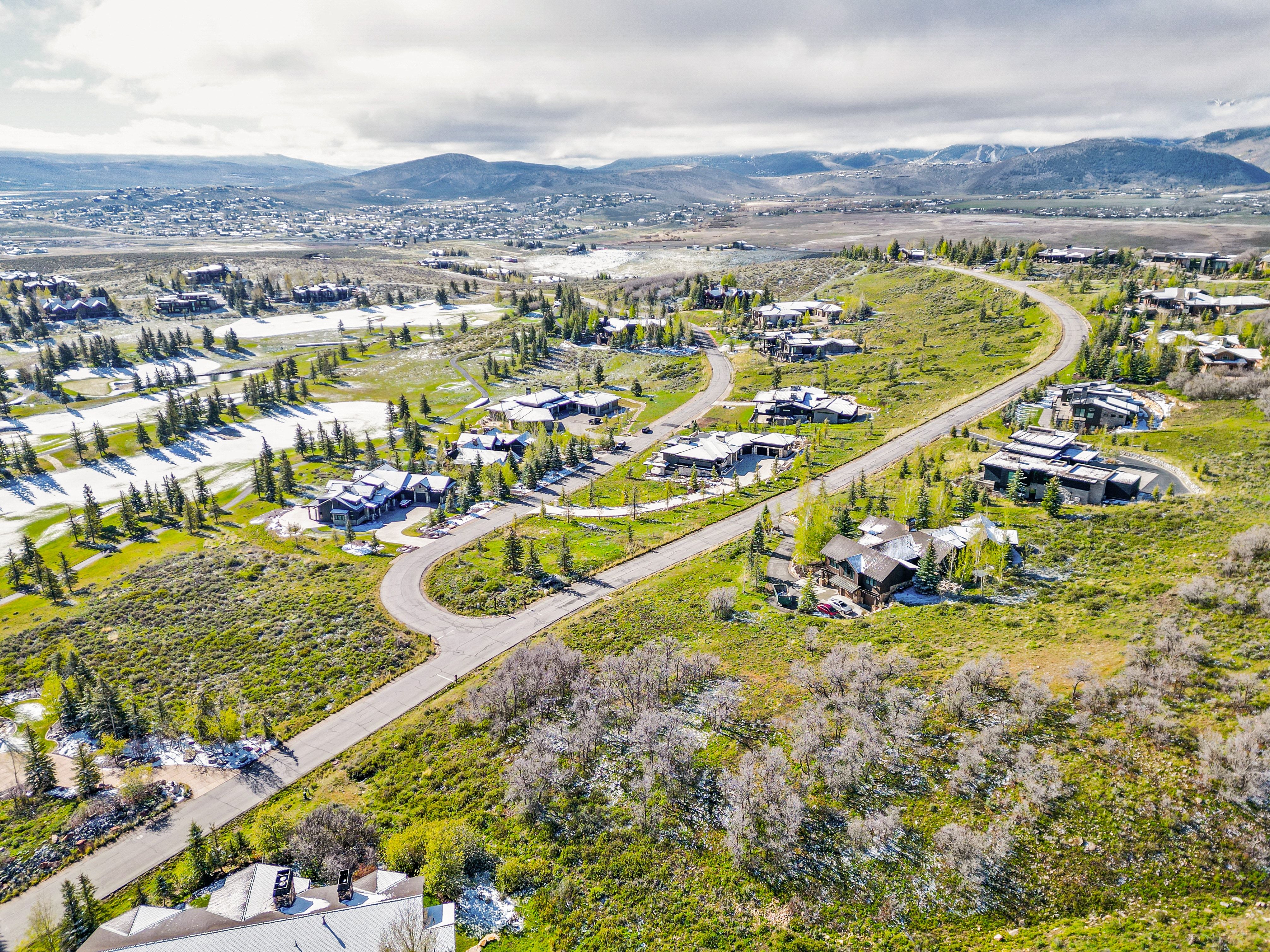 Aerial rendering of a residential area featuring multiple properties amidst natural landscaping and paved roadways