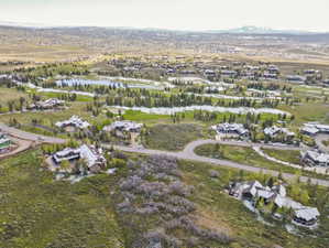 Aerial perspective showcasing a residential area with a golf course and water features