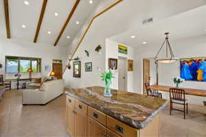 Vaulted ceiling featuring exposed wood beams and recessed lighting