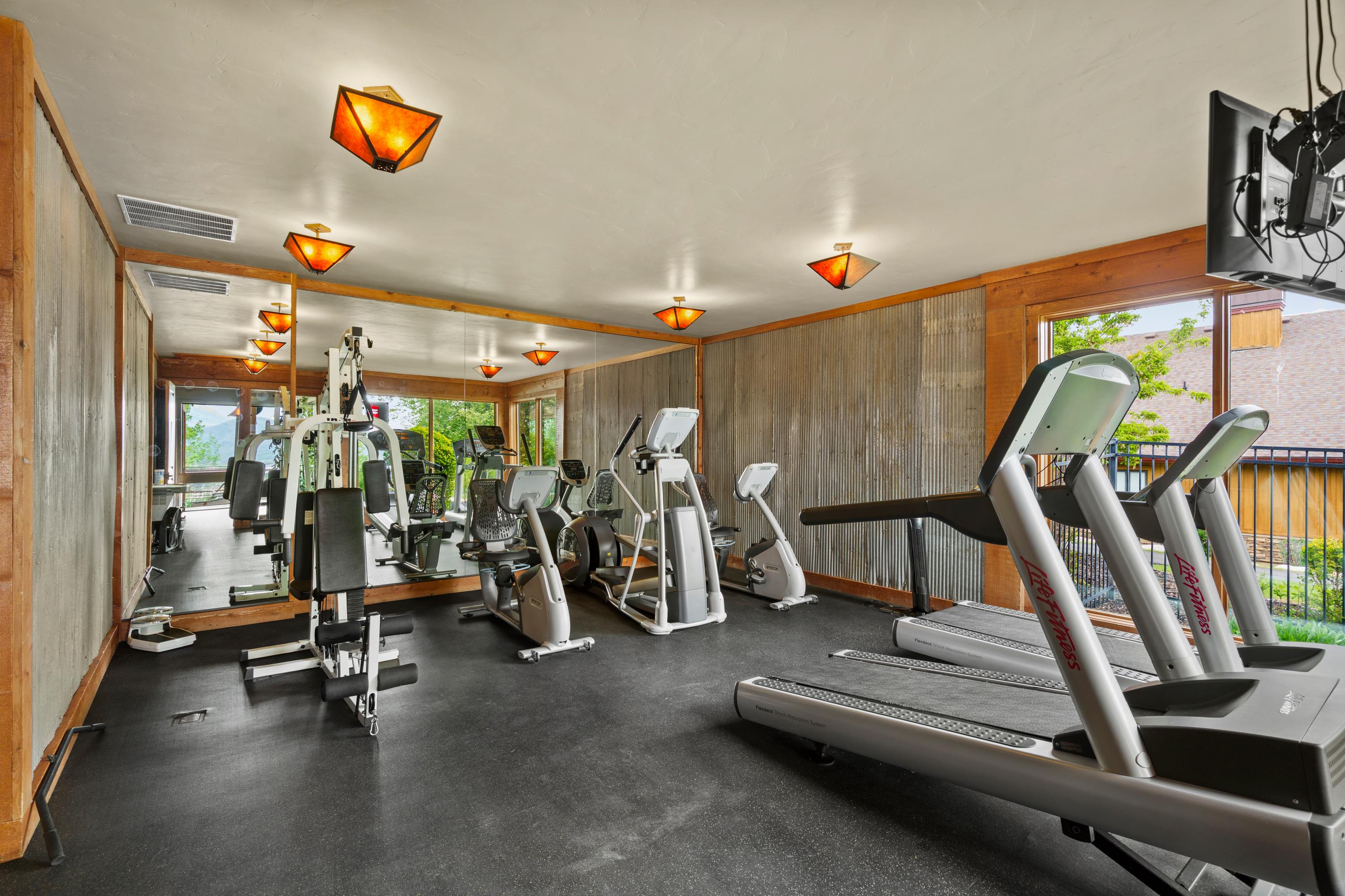 Dedicated fitness room featuring rubber flooring and full-wall mirrors