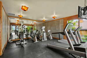 Dedicated fitness room featuring rubber flooring and full-wall mirrors