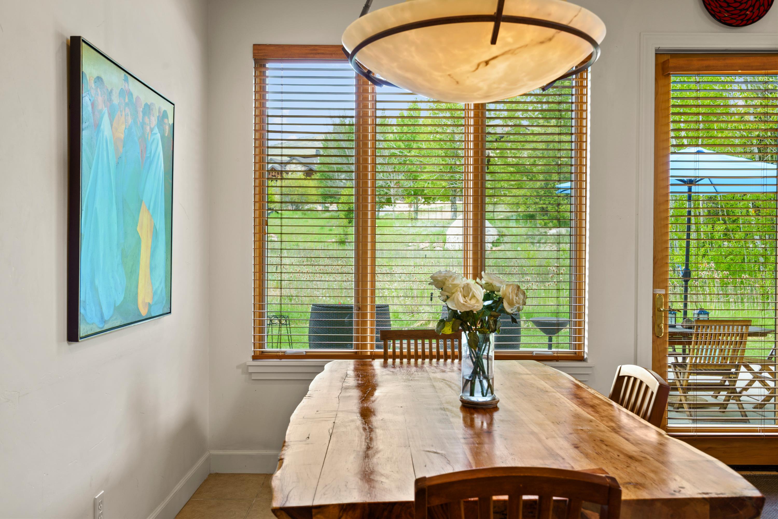 Hardwood dining table with natural edge, accompanied by wooden chairs