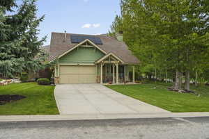 Front exterior with a two-car garage, covered porch entry, and visible solar panels