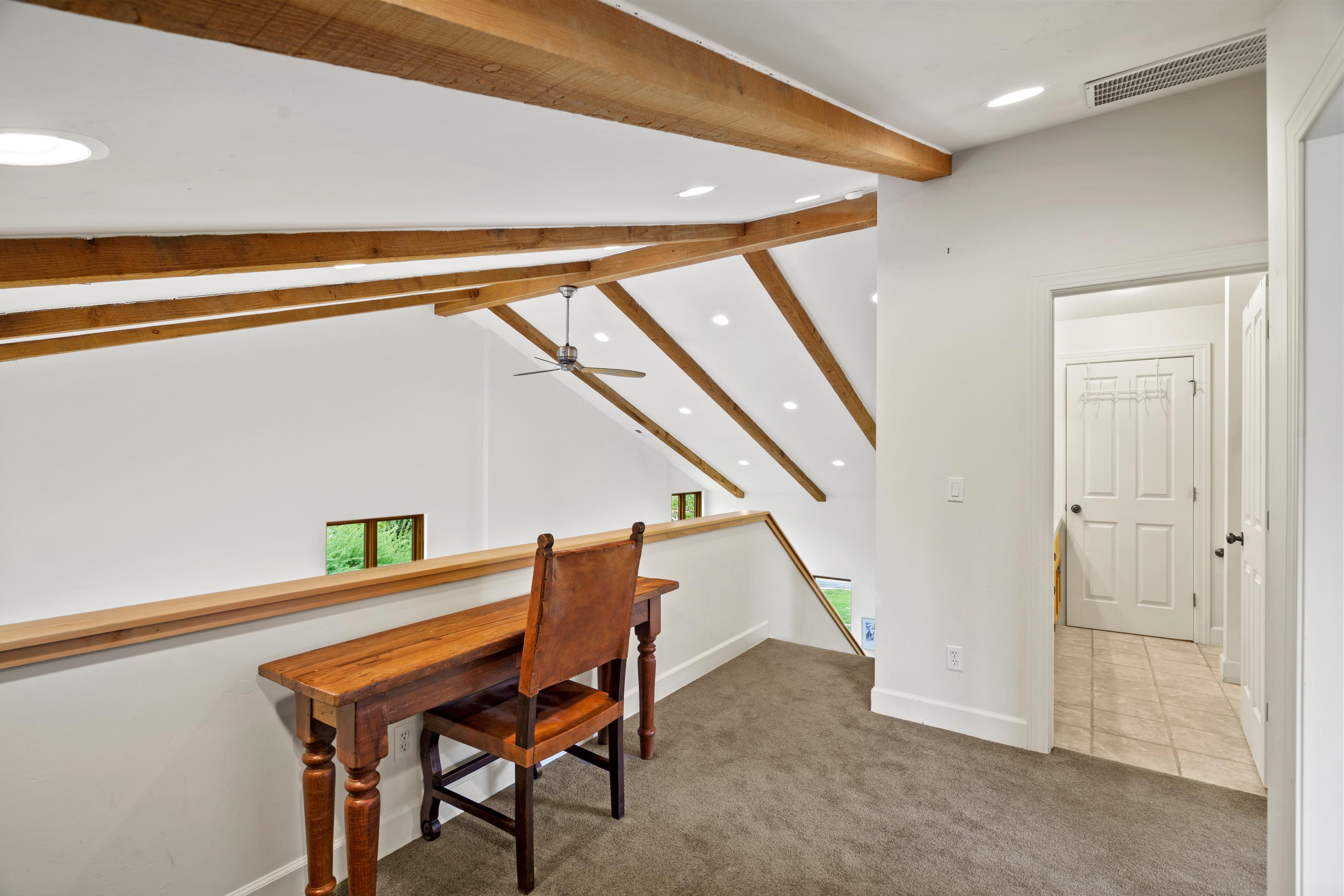 Loft area featuring exposed wood ceiling beams, recessed lighting, and a ceiling fan