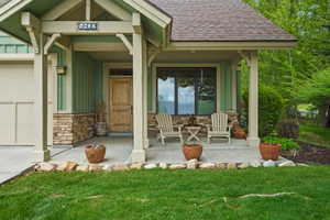 Front Entrance with a covered front porch, vertical siding, stone veneer accents.