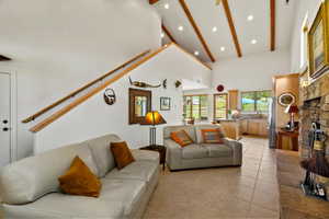 Living area with vaulted ceilings, exposed wood beams, and recessed lighting
