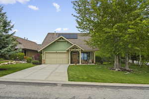 Ranch-style residence featuring a prominent front gable, a two-car garage, and a covered front porch
