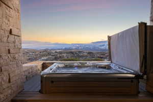 Outdoor spa featuring a wood-finish cabinet and cover lift system, set on wood-finish decking