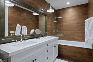 Bathroom featuring a double vanity with integrated sinks, white cabinetry, and polished chrome fixtures