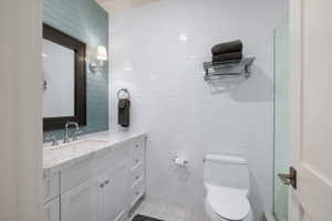 Bathroom featuring a white vanity with an integrated sink, quartz-finish countertop, and chrome fixtures