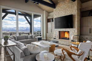 Spacious living area featuring large picture windows, a stone-clad fireplace, and built-in cabinetry