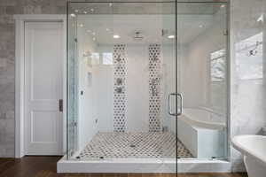 Glass-enclosed wet room featuring a built-in tub, dual shower heads, and multiple body jets