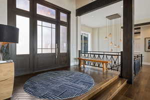 Grand entry featuring a dark wood door with sidelights and transom windows, complemented by wood-finish flooring
