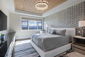 Tray ceiling with wood-finish paneling and a modern chandelier