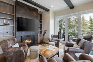 Stone-clad fireplace with built-in television, flanked by integrated custom shelving