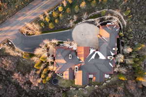 Expansive property featuring a circular driveway, multi-level roofing, mature landscaping, and an integrated outdoor recreation area