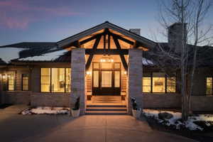 Stone and wood-beam entry with double doors and transom windows