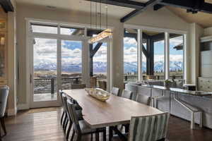 Dining area with expansive glass doors and windows, offering mountain scenery