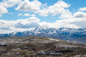 Expansive mountain landscape featuring snow-capped peaks and scattered residential developments