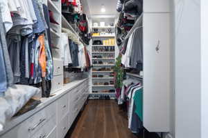 Custom walk-in closet featuring extensive built-in cabinetry, shelving, and hanging rods