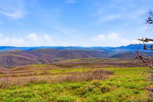 Rolling hills and distant mountains under a clear blue sky