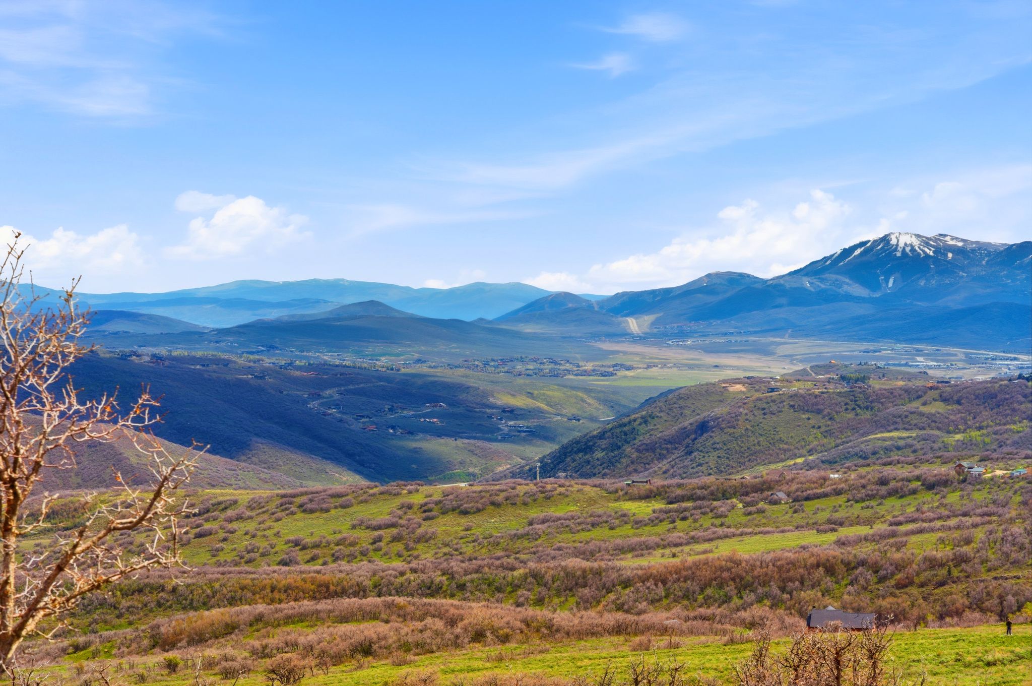 Expansive mountain landscape featuring varied elevations and distant snow-capped peaks