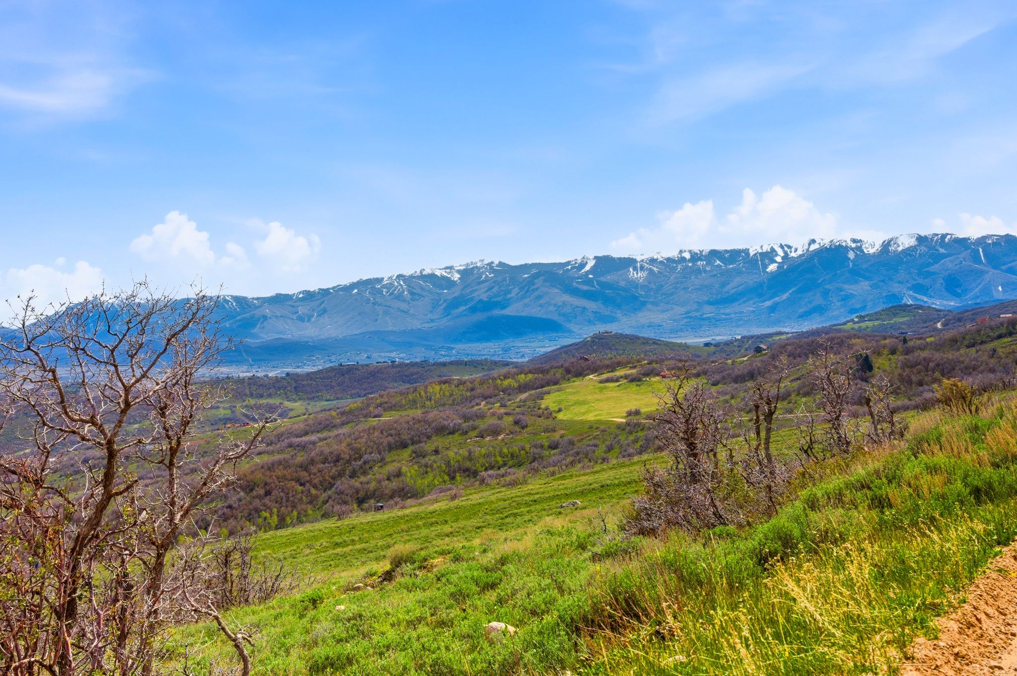 Expansive mountain terrain featuring snow-capped peaks in the distance