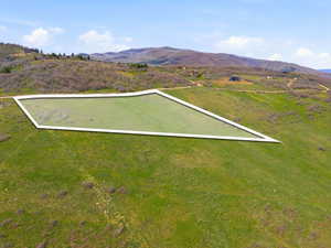Expansive parcel of land with a rectangular outline, featuring a gentle slope and partial grass coverage