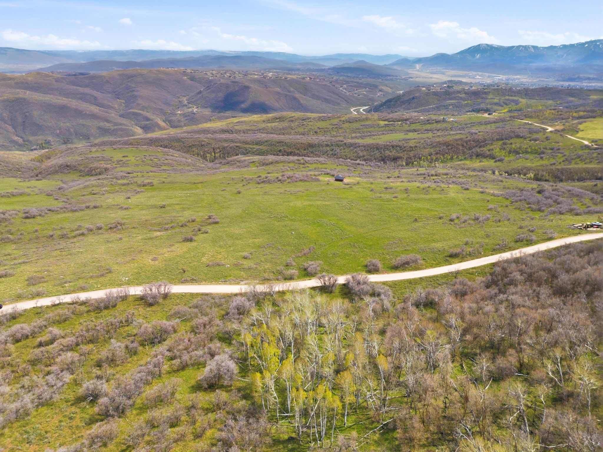 Expansive natural landscape featuring rolling hills and distant mountains