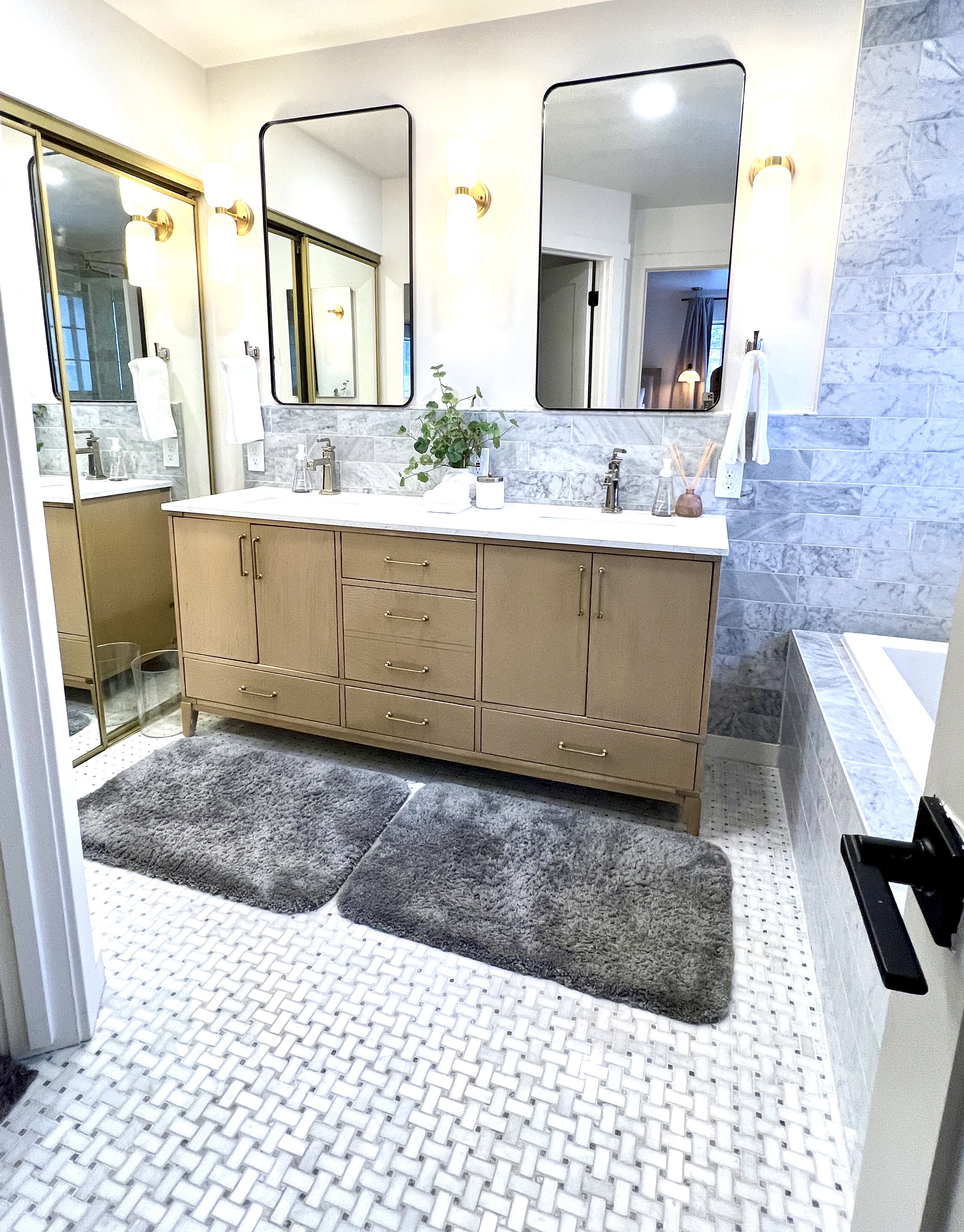 Double vanity with natural wood-finish cabinetry and brushed gold hardware