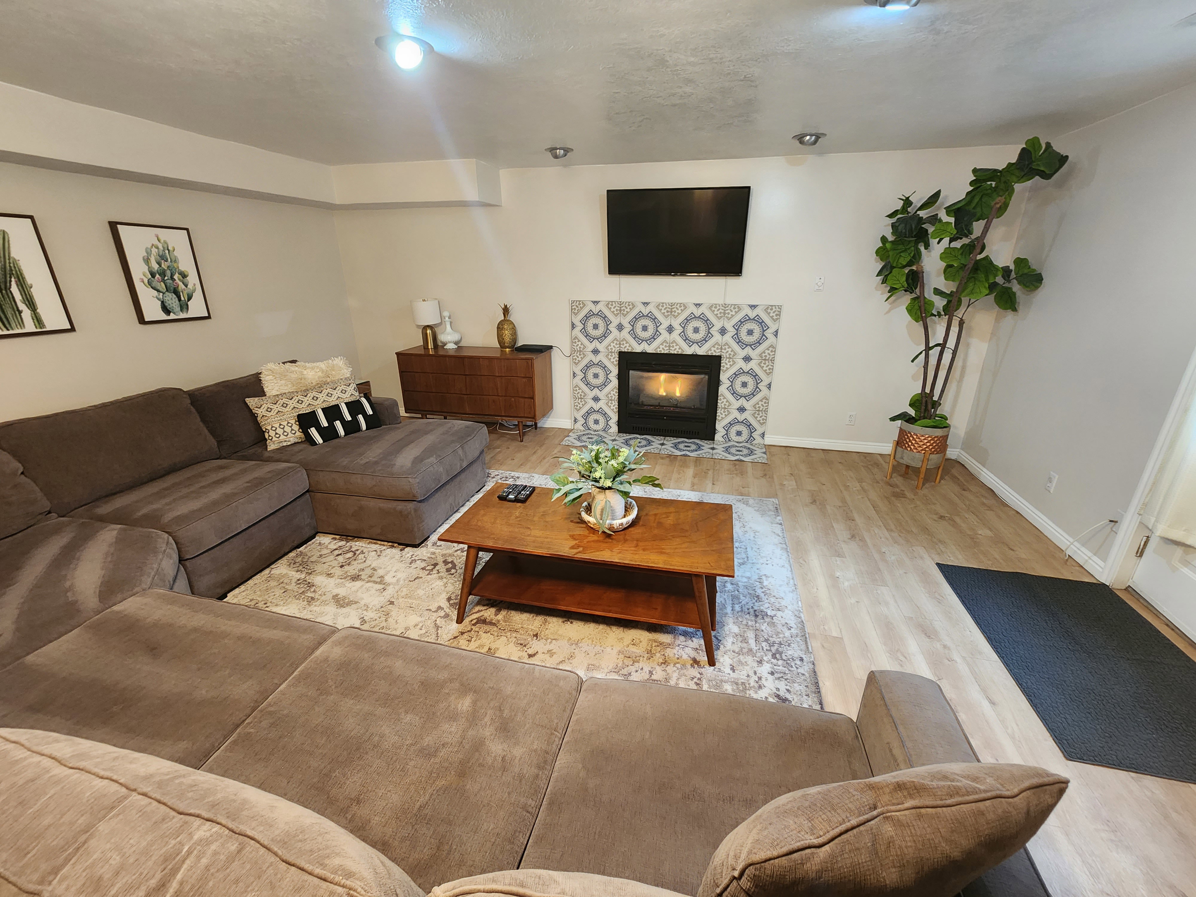 Living area featuring light wood-finish flooring, recessed lighting, and a fireplace with decorative tile surround