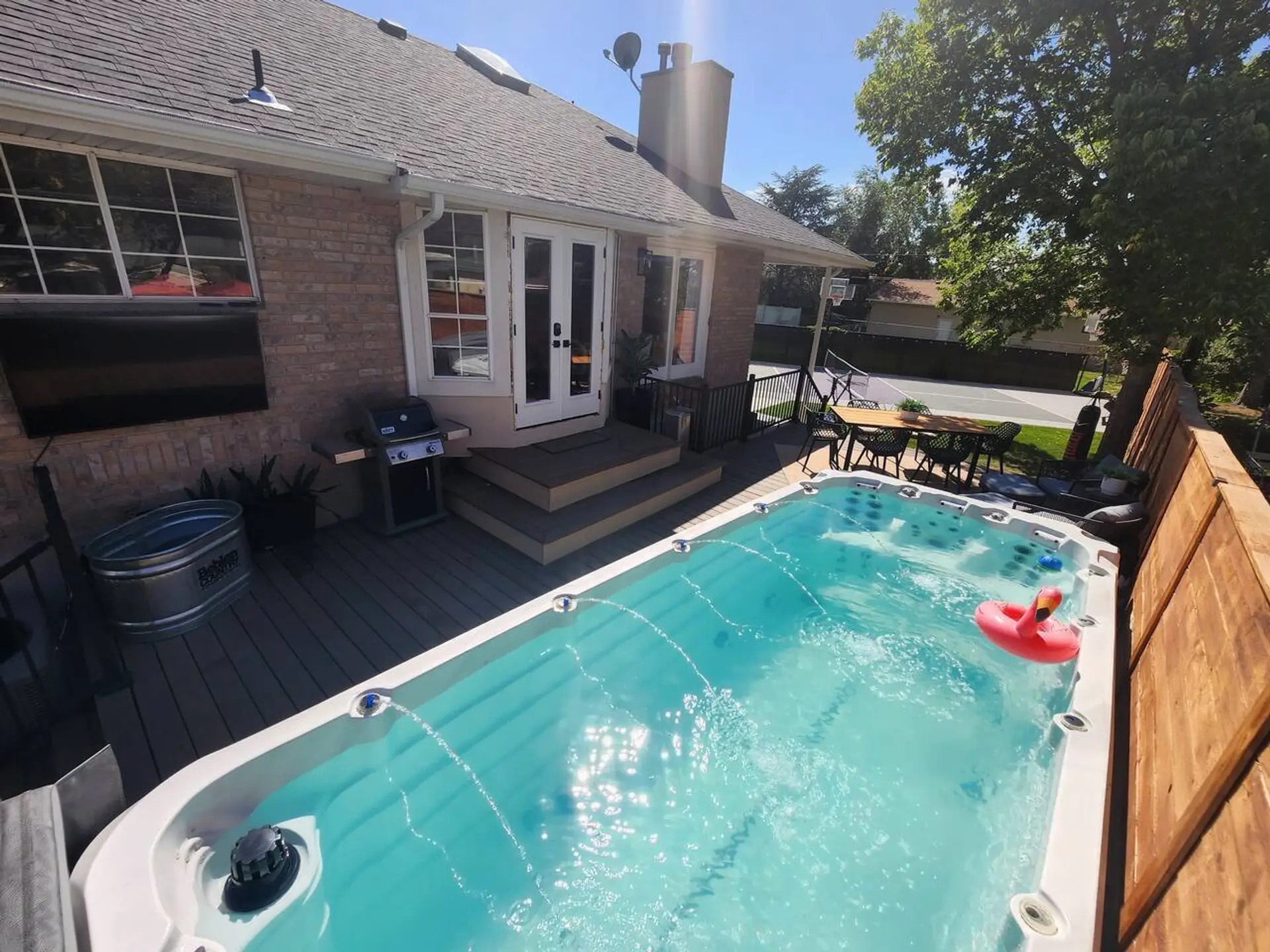 Outdoor swim spa with active jets, complemented by a multi-level composite deck