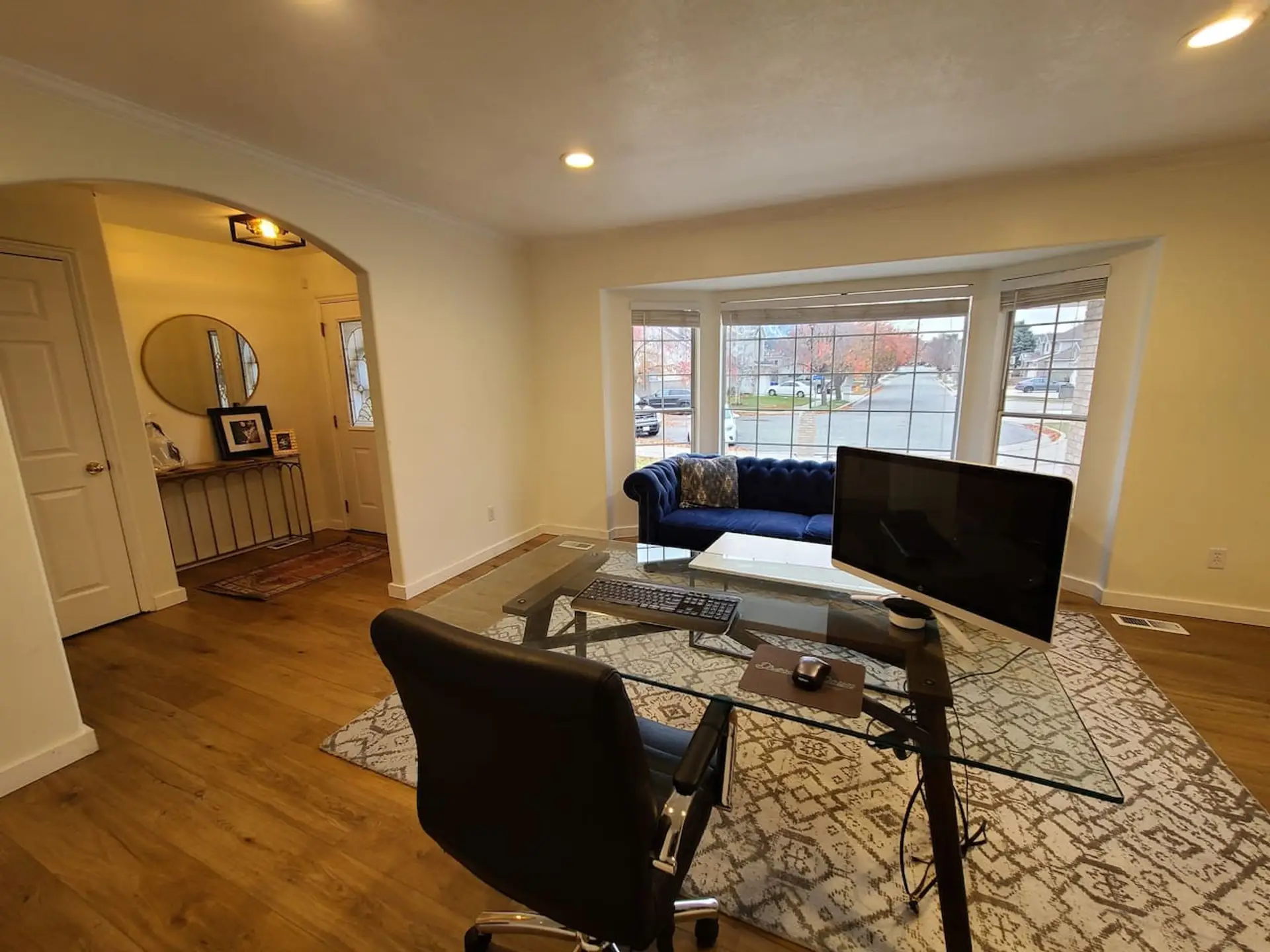 Expansive front room featuring wood-finish flooring and a large bay window