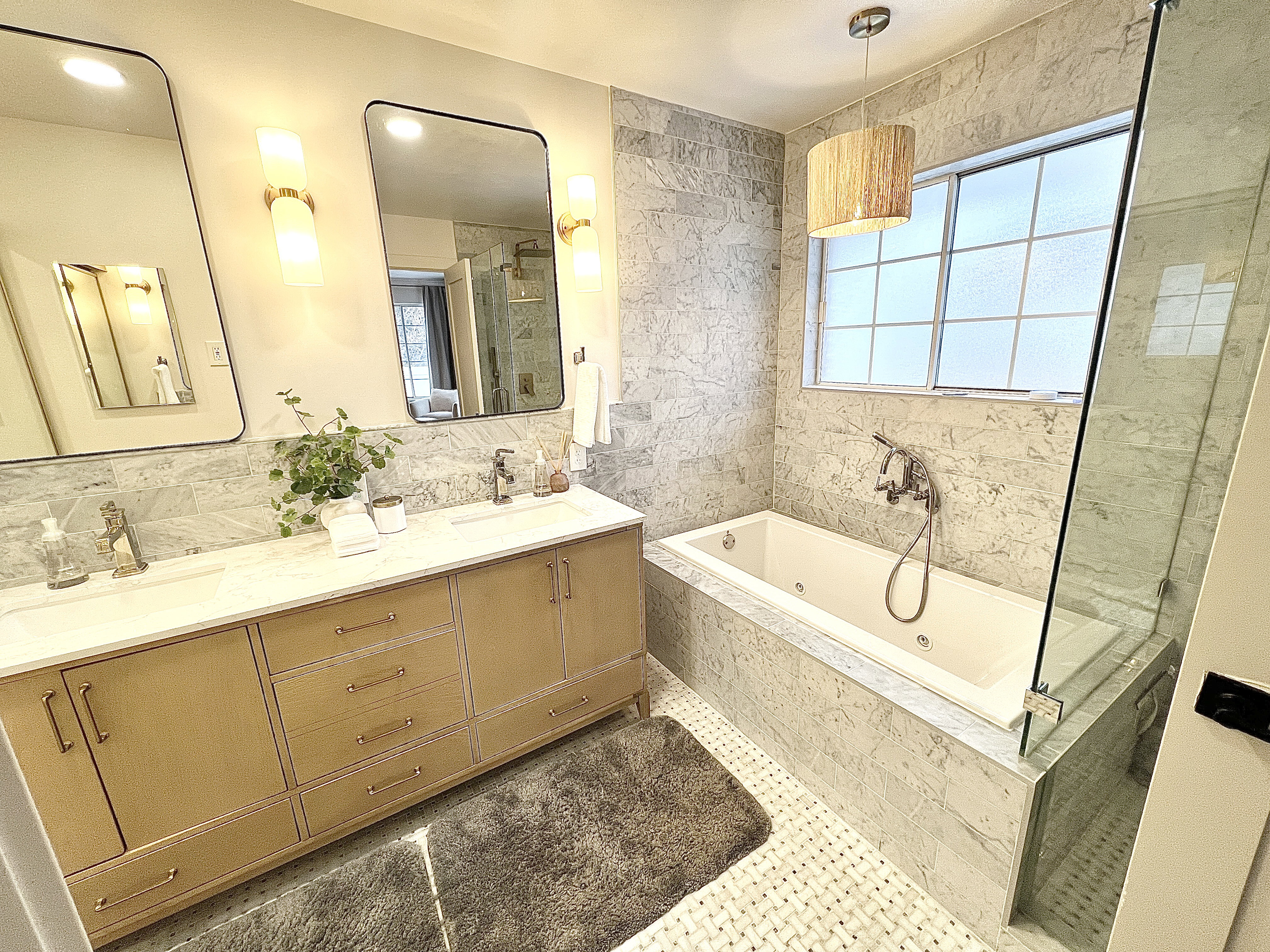 Luxurious bathroom featuring a dual vanity with a light wood-finish cabinet, quartz countertop, and integrated sinks